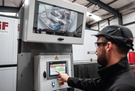 Operator reviewing a supervisory dashboard for a robotic production line